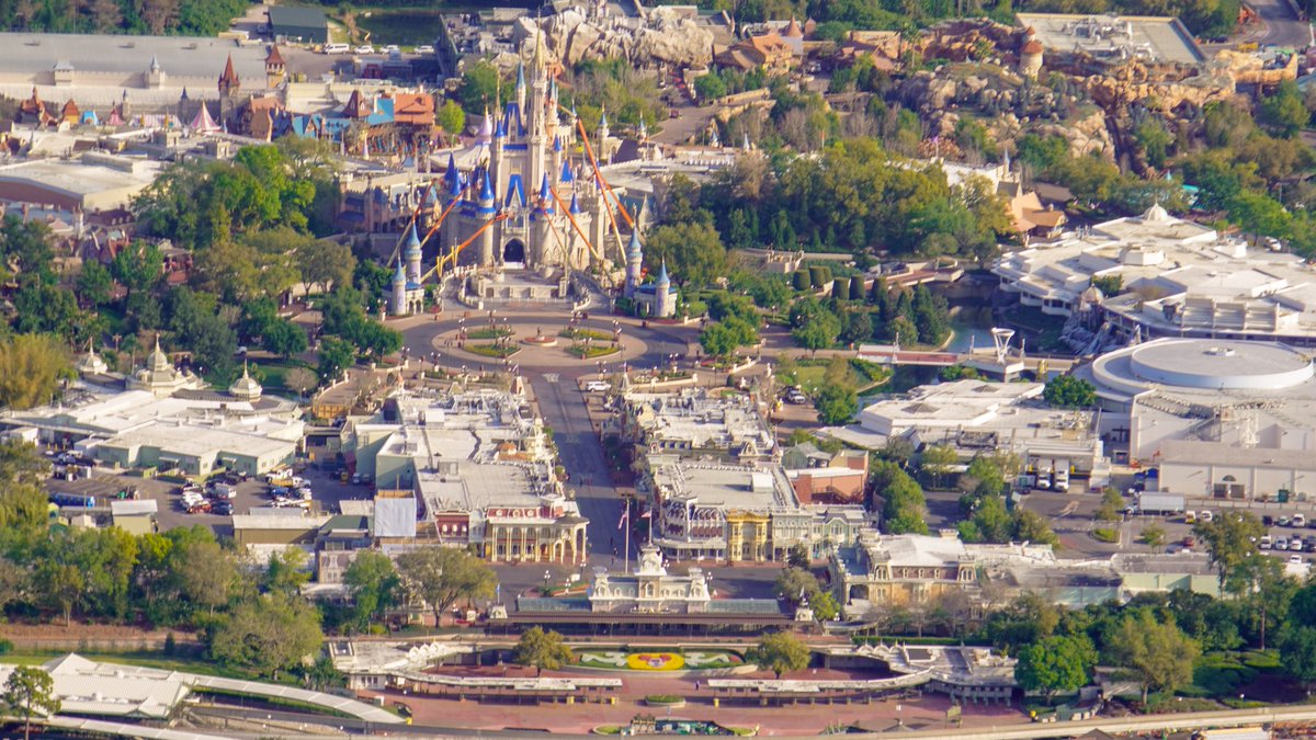 bioreconstruct's tweet photo. Aerial view of Magic Kingdom. Closed starting today due to Covid-19. Empty Main Street USA. Notice also the boom lifts with workers painting Cinderella Castle for the 50th anniversary. https://t.co/N0HGrFLiSU