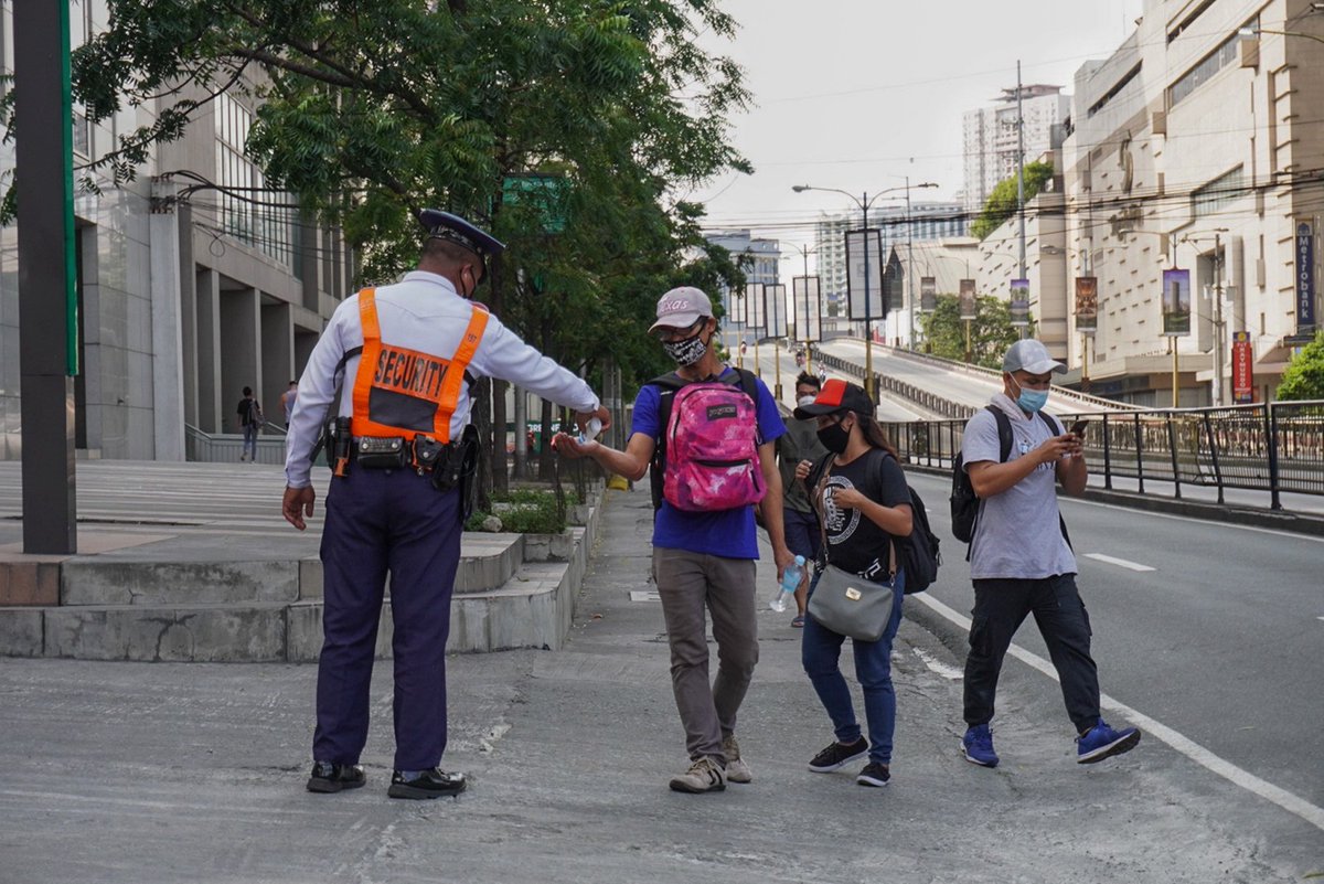 ABSCBNNews's tweet photo. LOOK: Nicko Gloriana, a security guard of a condominium in Mandaluyong, offers to spray alcohol to passersby along Shaw Boulevard. The security guard says this is the least he could do to help Filipinos under lockdown. #COVID19quarantine | via Bernice Beltran, ABS-CBN News https://t.co/3xT0kXS73q