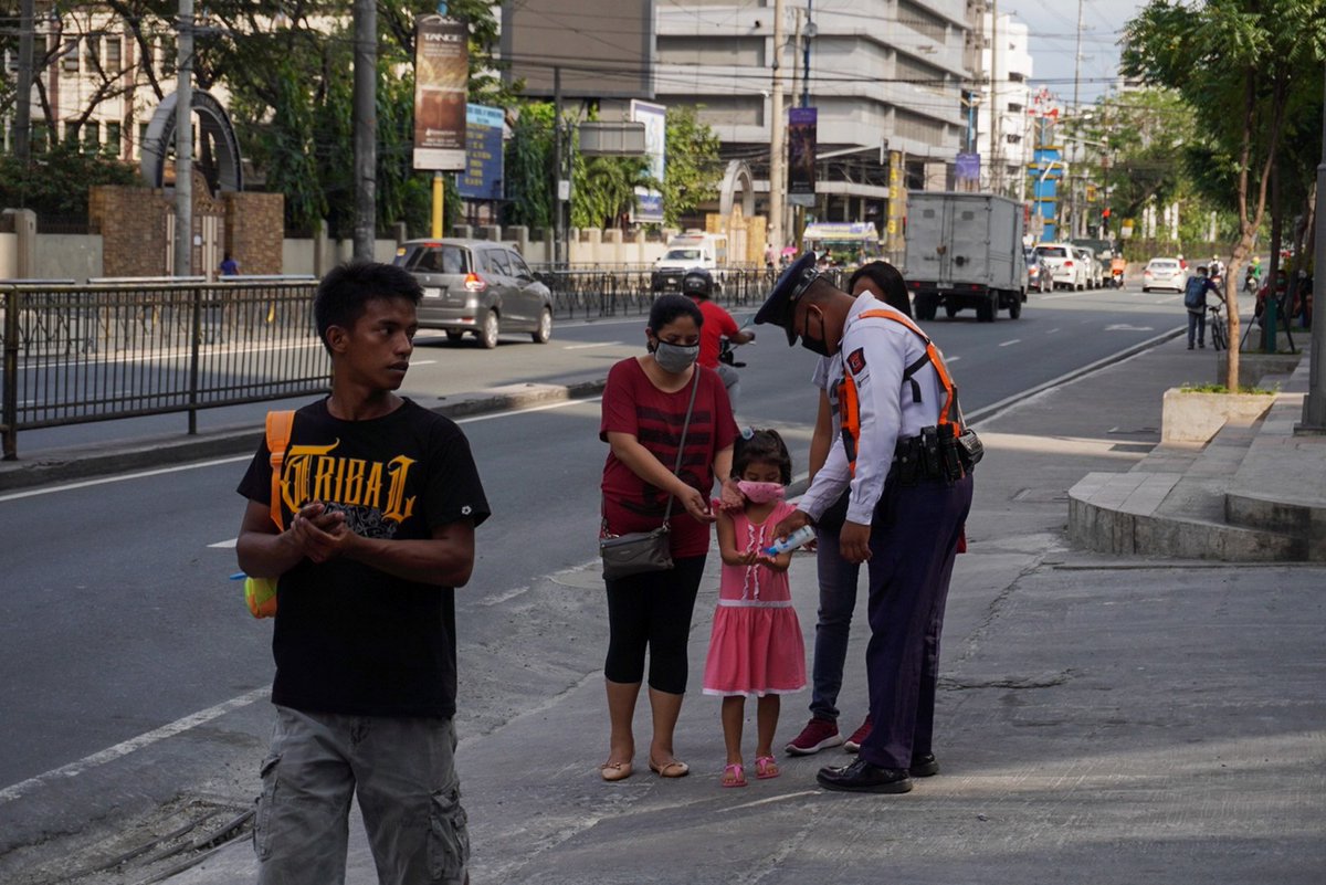 ABSCBNNews's tweet photo. LOOK: Nicko Gloriana, a security guard of a condominium in Mandaluyong, offers to spray alcohol to passersby along Shaw Boulevard. The security guard says this is the least he could do to help Filipinos under lockdown. #COVID19quarantine | via Bernice Beltran, ABS-CBN News https://t.co/3xT0kXS73q