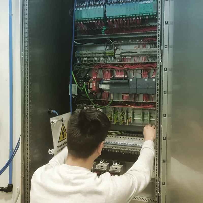 Adelphi_Group's tweet photo. No project too big or too small! ☺️ Our #apprentice #electricalfitter Patrick is wiring this 2m tall cabinet for an #ATEX Boom Arm Filler - it will sit outside the ATEX zone in our customer’s #pharmaceuticalmanufacturing plant ☺️ #ukmfg #automation #ukmanufacturing https://t.co/6UF5ClnwS7