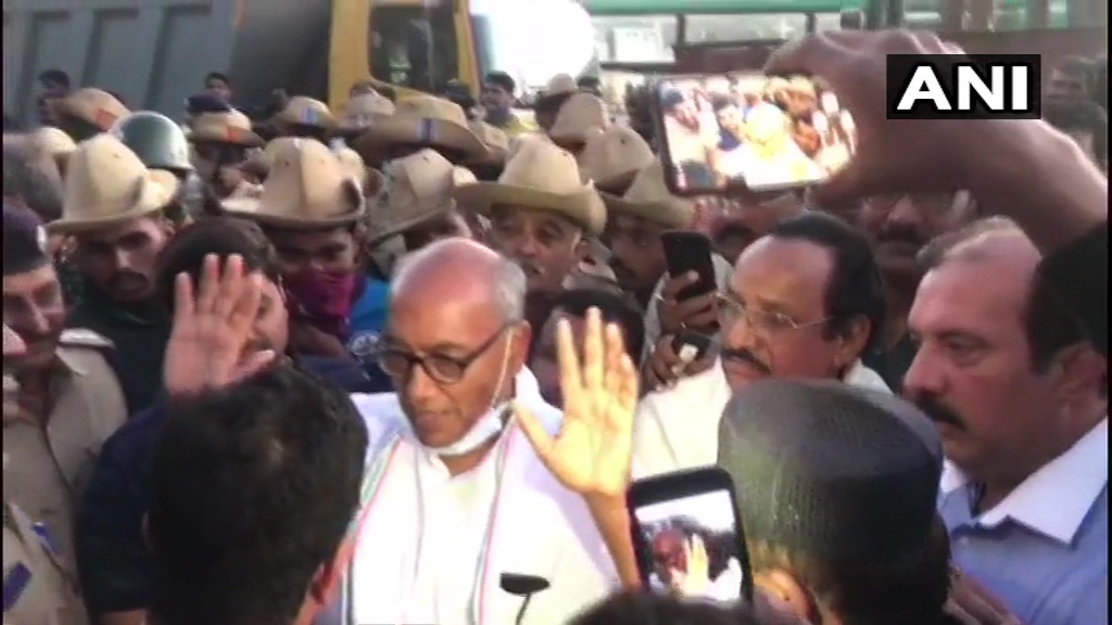 ANI's tweet photo. Bengaluru: Congress leader Digvijaya Singh sits on dharna near Ramada hotel, allegedly after he was not allowed by police to visit it. 21 Madhya Pradesh Congress MLAs are lodged at the hotel. https://t.co/wyPcfvci3f