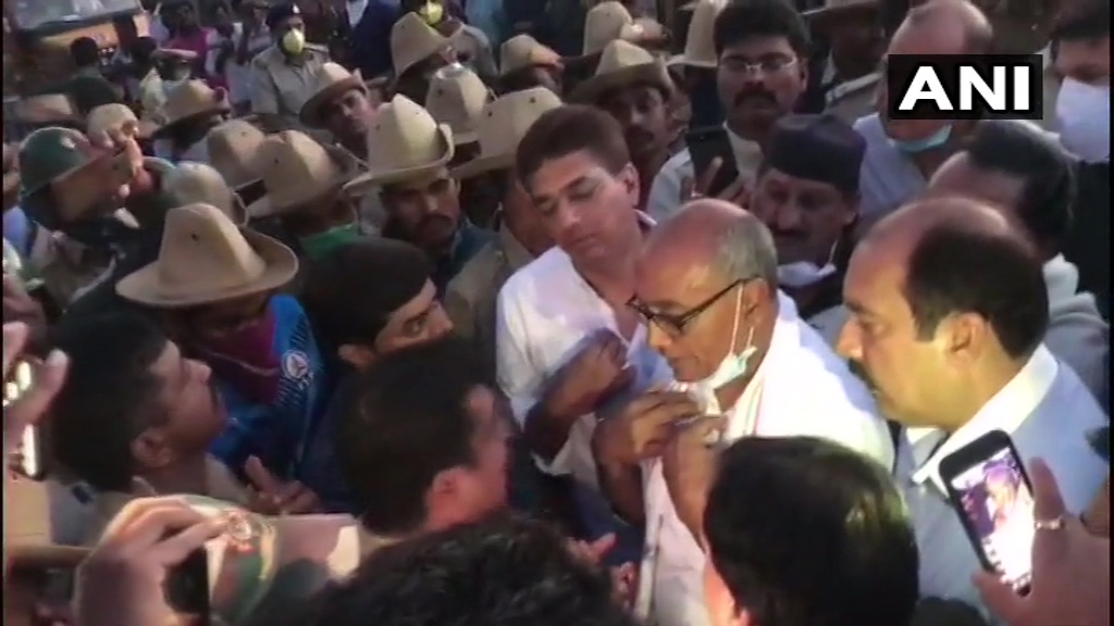 ANI's tweet photo. Bengaluru: Congress leader Digvijaya Singh sits on dharna near Ramada hotel, allegedly after he was not allowed by police to visit it. 21 Madhya Pradesh Congress MLAs are lodged at the hotel. https://t.co/wyPcfvci3f