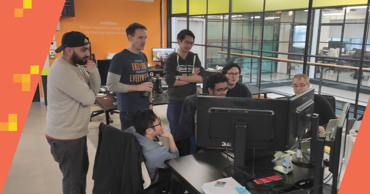 members of the tech team crowd around computer.