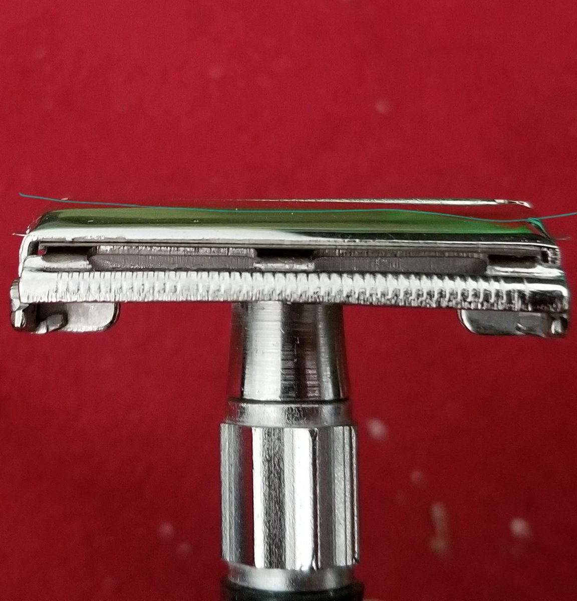 The black west coast shaving head I put on the handle for the $80 brand I have, warps the blade terribly with a sizeable bump in the middle, while the cheap barber supply razor with a chrome head holds the blade straight