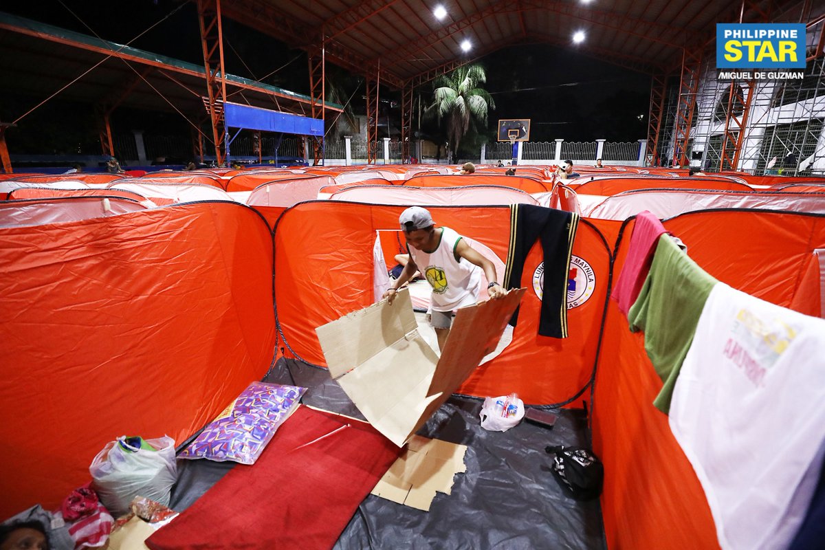 Rescued street dwellers set up sleeping areas inside individual modular tents provided by the local government at the Delpan Sports Complex in Manila on Saturday midnight as part of their initiative to house homeless Manileños amid the COVID-19 threat.