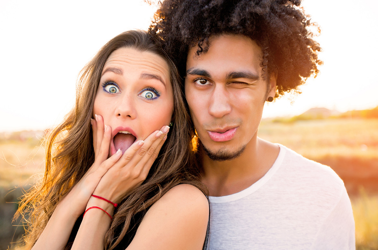 Молодежь в телефонах. Чат пары иностранных. Общение людей. Пара удивляется. Чат пары иностранных.