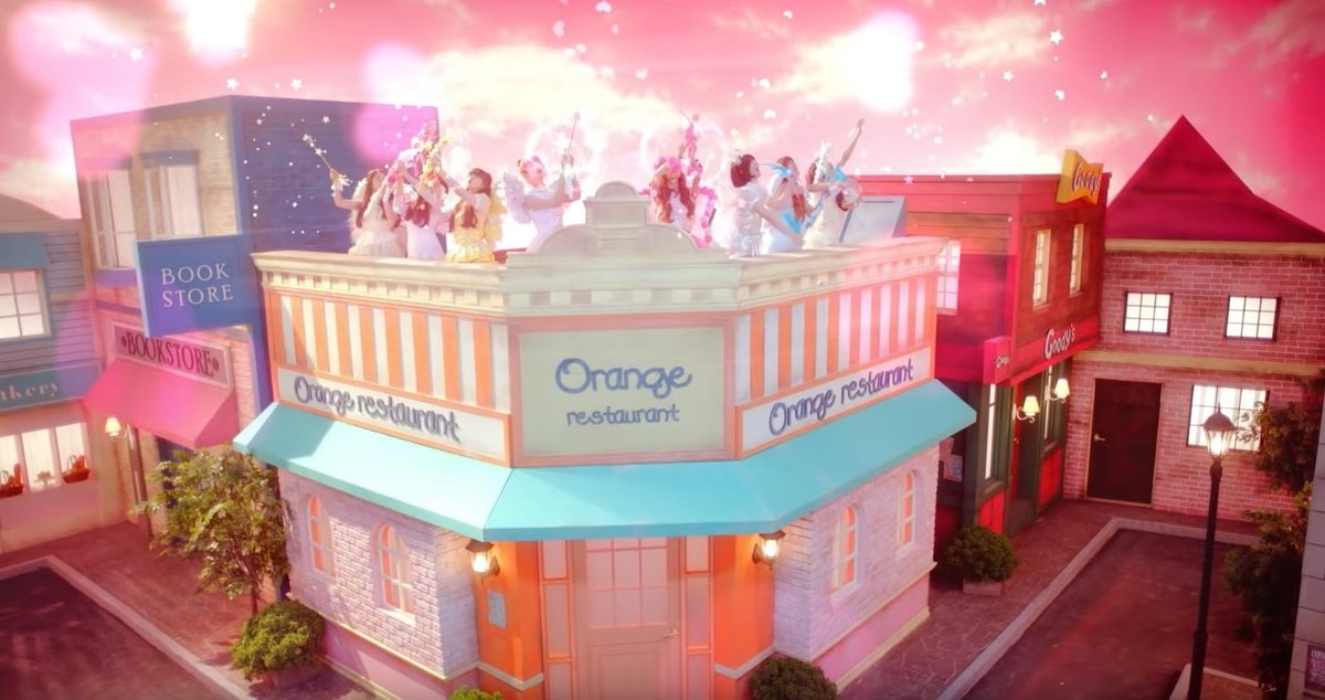Cupid:There are no fruits to be found throughout any scene in this music video. However, in the plaza scenes, "Orange Restaurant" is a building found in the background. The name of the restaurant possibly in reference to the fruit of the same name.