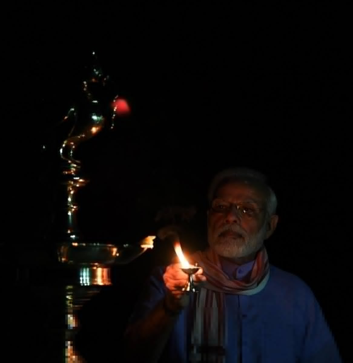 ANI's tweet photo. Delhi: PM Narendra Modi lights a lamp after turning off all lights at his residence. India switched off all the lights for 9 minutes at 9 PM today &amp; just lit a candle, 'diya', or flashlight, to mark India's fight against #Coronavirus as per his appeal. https://t.co/apLIVmMCTf