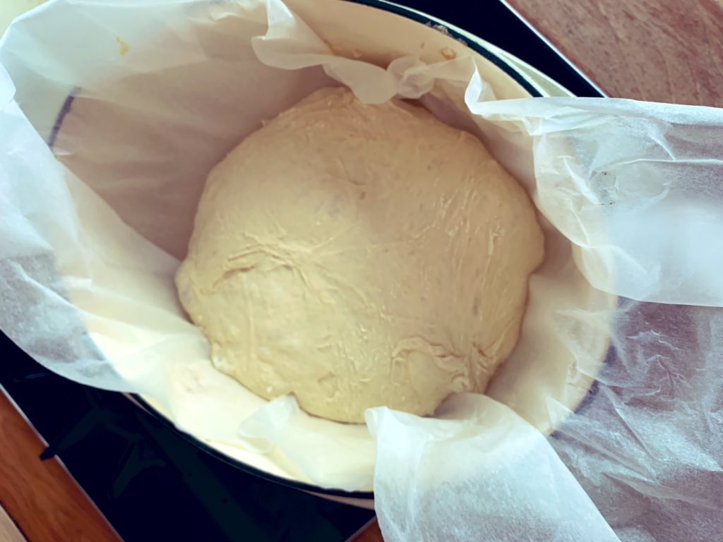 After 15 mins, carefully take your casserole dish out of the oven, it will be very hot, and pop the dough, still in the paper, into the dish. Cover and put it back in the oven. Bake for 40 mins. Then remove the lid and bake for another 15 mins to get the crust nice and golden.