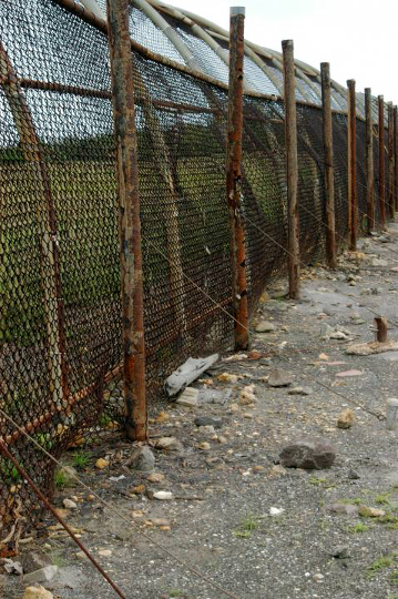 6/ Here is another view of the perimeter fence after a normal launch. See the rusty old fence posts in front of the newer fence, plus other posts cut off near the soil? That's because the pummeling of rubble kept damaging the fence, so it needed to be periodically replaced.