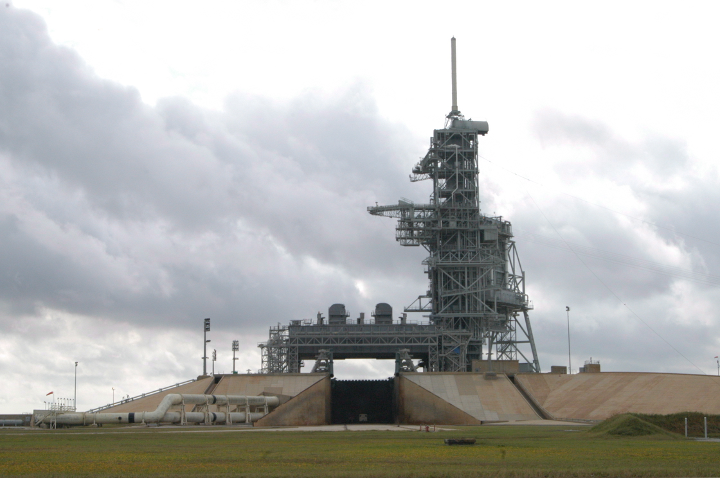 9/ For perspective, I took this picture with my back to the same fence to show how far away the launch pad is. That is a large truck inside the flame trench, for scale. Imagine the boulders ripping out of the flame trench then flying this distance before slamming into the fence.