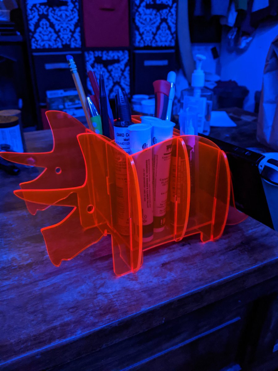 LaserMistress's tweet photo. Day 8 of 30 days of lasercutting. Snap fit florescent pink triceratops organizer. I needed it for the inexplicable amount of weed pre-rolls, pencils and thin tools that gather on my coffee table. Bonus: it can hold my Switch! #laserartist #glowforge https://t.co/wBRSwQlhnl