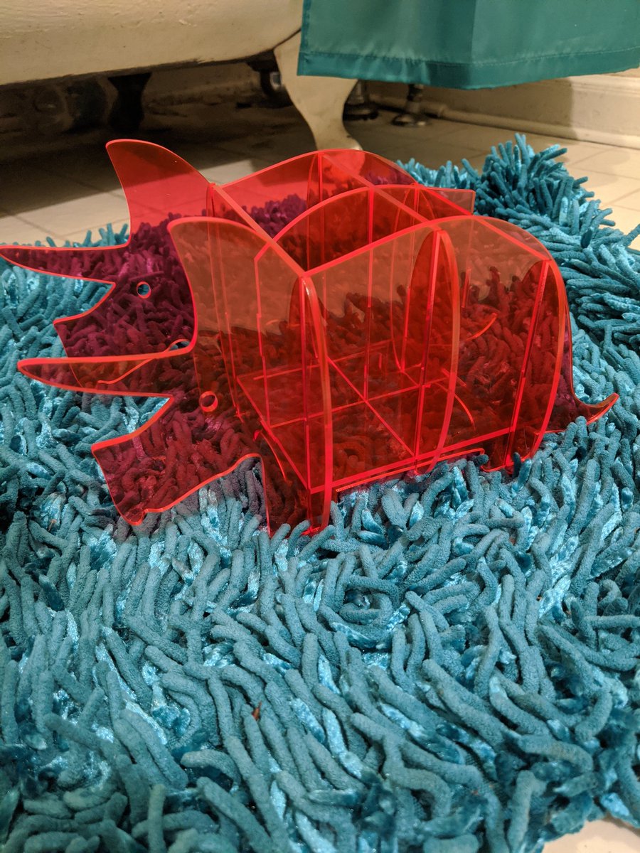 LaserMistress's tweet photo. Day 8 of 30 days of lasercutting. Snap fit florescent pink triceratops organizer. I needed it for the inexplicable amount of weed pre-rolls, pencils and thin tools that gather on my coffee table. Bonus: it can hold my Switch! #laserartist #glowforge https://t.co/wBRSwQlhnl