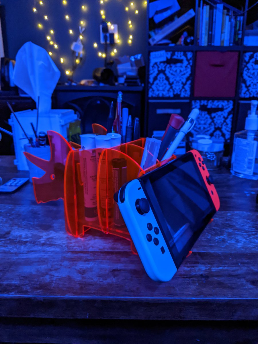 LaserMistress's tweet photo. Day 8 of 30 days of lasercutting. Snap fit florescent pink triceratops organizer. I needed it for the inexplicable amount of weed pre-rolls, pencils and thin tools that gather on my coffee table. Bonus: it can hold my Switch! #laserartist #glowforge https://t.co/wBRSwQlhnl