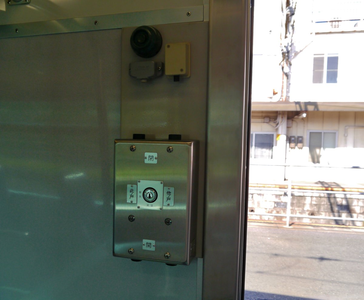 鉄道 名鉄電車の車内にあるドアスイッチと、一般列車で輸送中の新聞