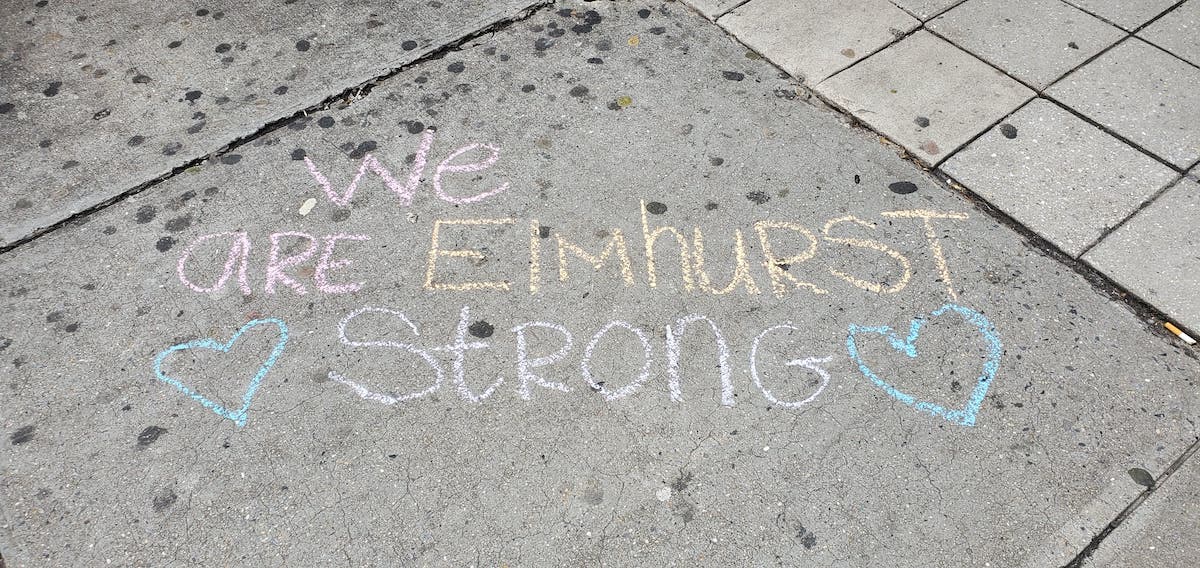 Sidewalk chalk reads, "We are Elmhurst strong."