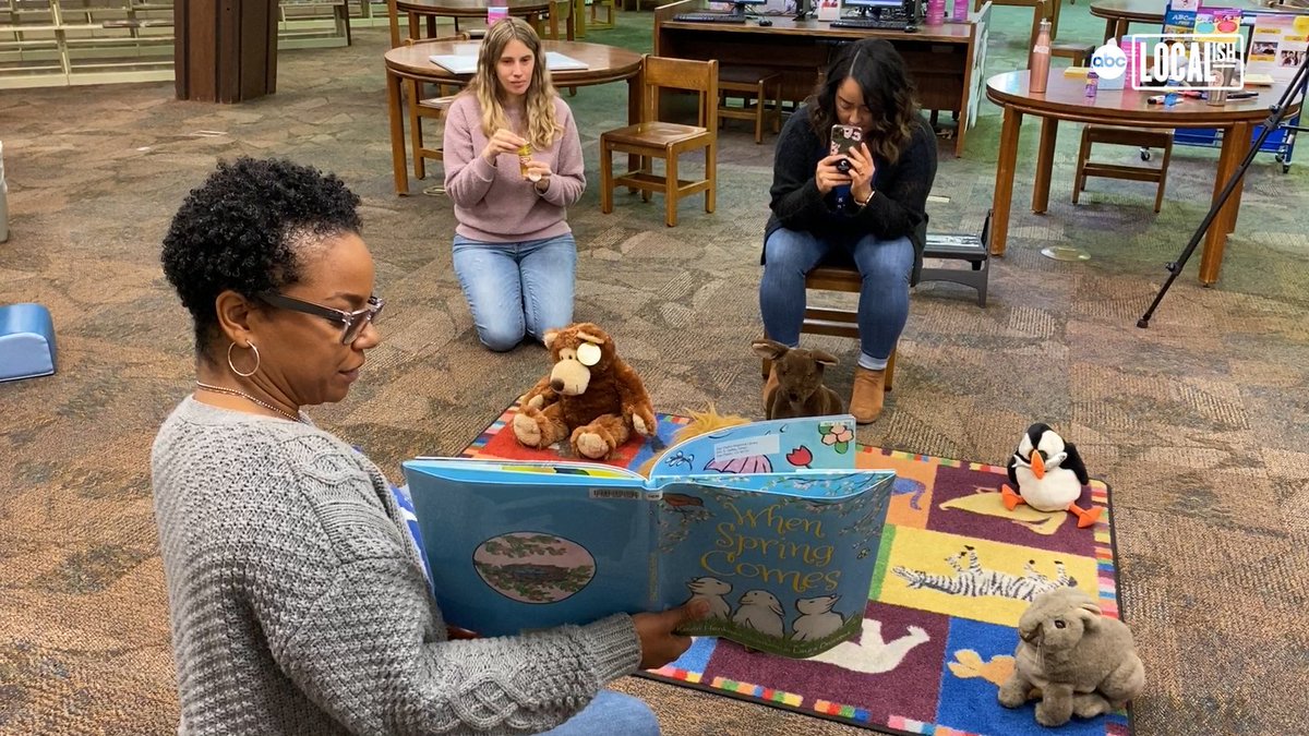 librarian reading book to stuffed animals