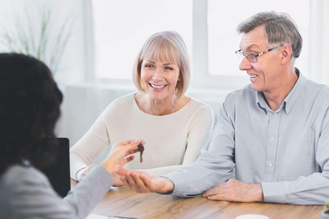 Asian couple sign home contract and handshake with realtor