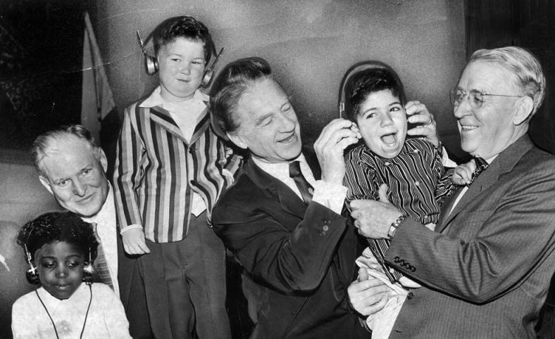 3 men and 3 children listening to headphones