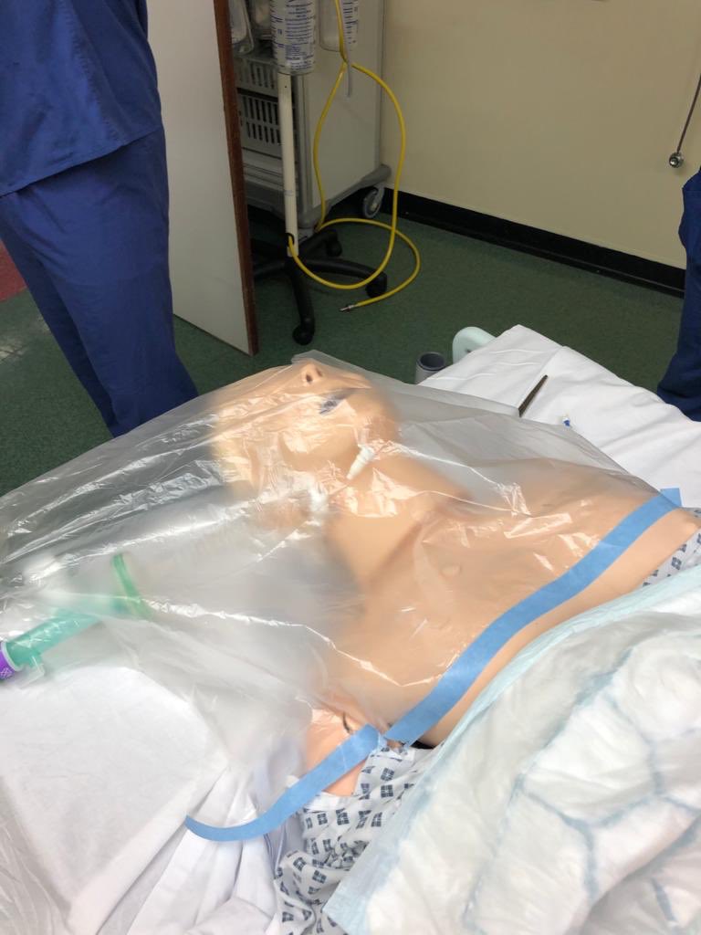 ATACCGroup's tweet image. This is our simple, cheap solution to safe hands only resus until help in full PPE arrives - c’mon @ResusCouncilUK think outside the box. Adhesive strip, large clear sheet, aerosol condenses on face. #Tooltime bought on a roll. #Covid_19