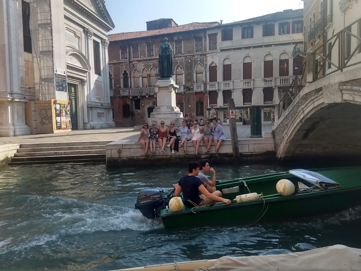 IsabelWilliams0's tweet photo. Okay so this summer when we studied abroad, we took a trip to Venice &amp; someone offered to take this picture of us. When they did these two guys drove by on the boat and ever since then we’ve been on the hunt to find these impressive photo bombers. Twitter do your thing, pls. https://t.co/Ku0JTkDaFy