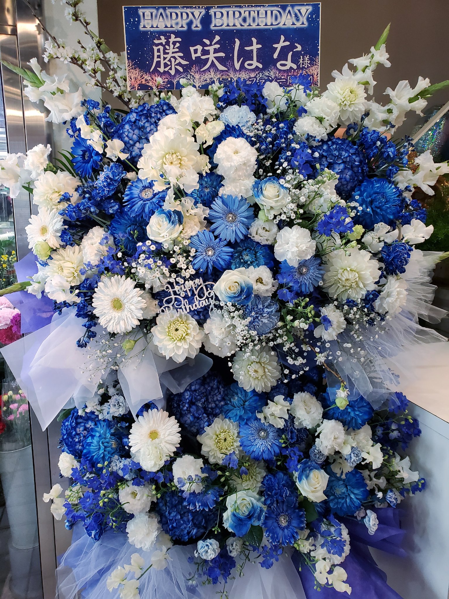 秋葉原のお花屋さん 花文 Hanabun さくらシンデレラの藤咲はな様宛のスタンド花 です 今年もロイヤルブルー 白でお洒落に大人っぽくお作り致しました ガーベラ ダリア バラ カスミ草等 あと さくらシンデレラさんなのでさくらも入れてみました