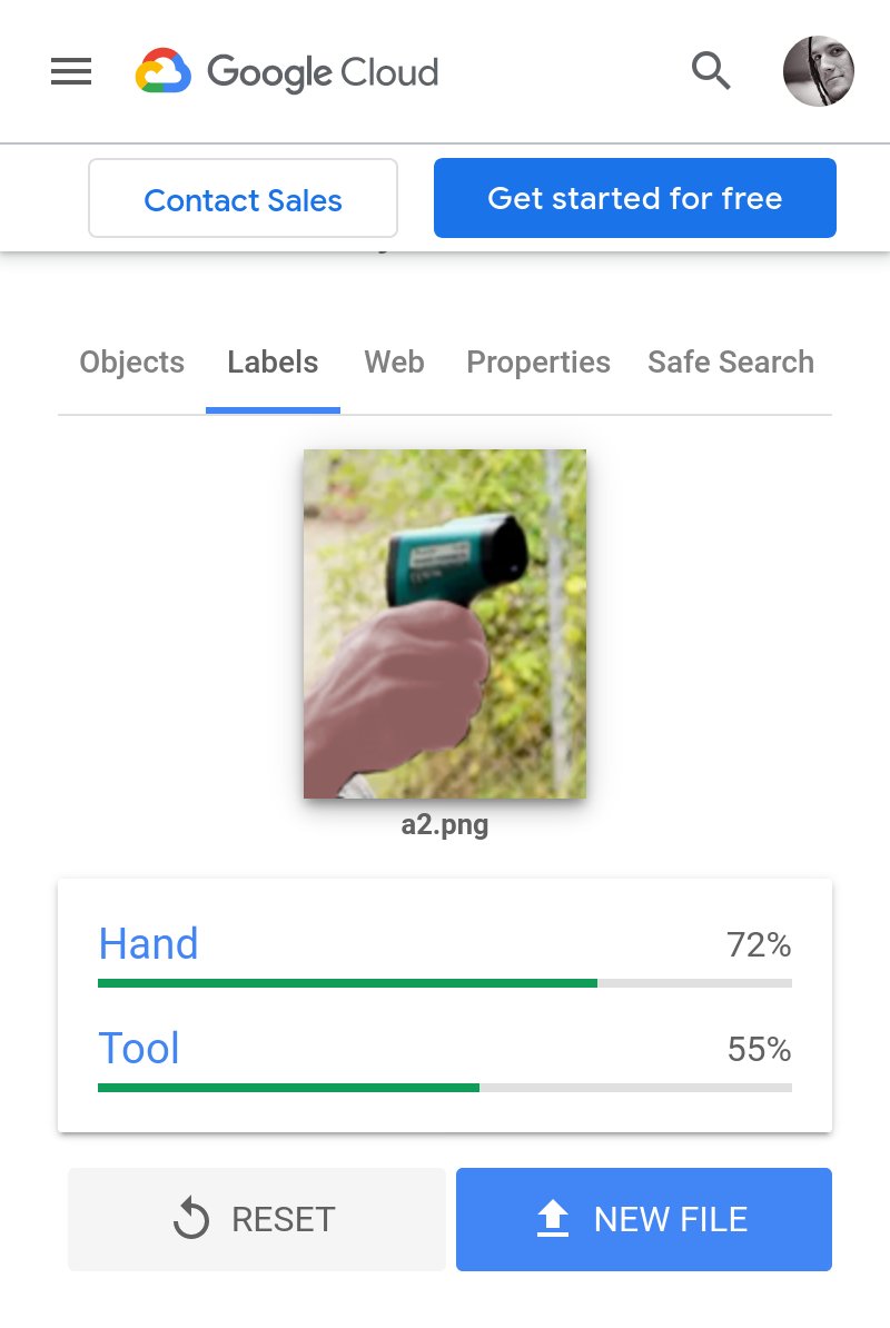 A crop of the original photo of the black person holding a thermometer, showing only the hand and device. This one has been (inexpertly) edited to lighten and recolour the person's skin to be a more pale complexion, and some of the shading has been washed out. Most people would probably guess the person is white. Google's results say that it is 72% hand, 55% tool (not gun at all).