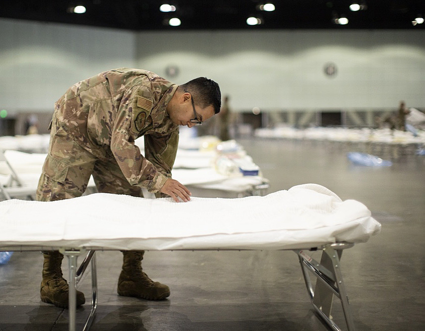 AirNatlGuard's tweet photo. Tech. Sgt. Mario Lopez-Casas from the @146AirliftWing puts sheets on a hospital bed while setting up a Federal Medical Station inside the Los Angeles Convention Center.  #covid_19 #NationalGuard

Full @CalGuard Story 🔗: https://t.co/WAelx40kHn
📸: Staff Sgt. Crystal Housman https://t.co/Q4ZJOAEgex