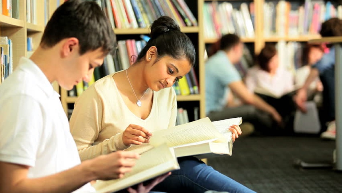 She study for her exams. студент за партой. студентка сидит за партой. девушка изучает документы. She study for her exams.