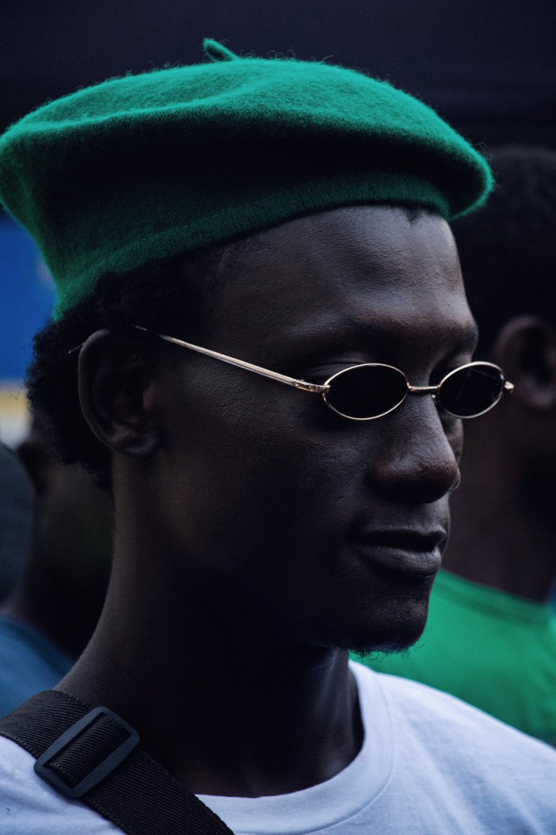 A black man in a beret photographed by 