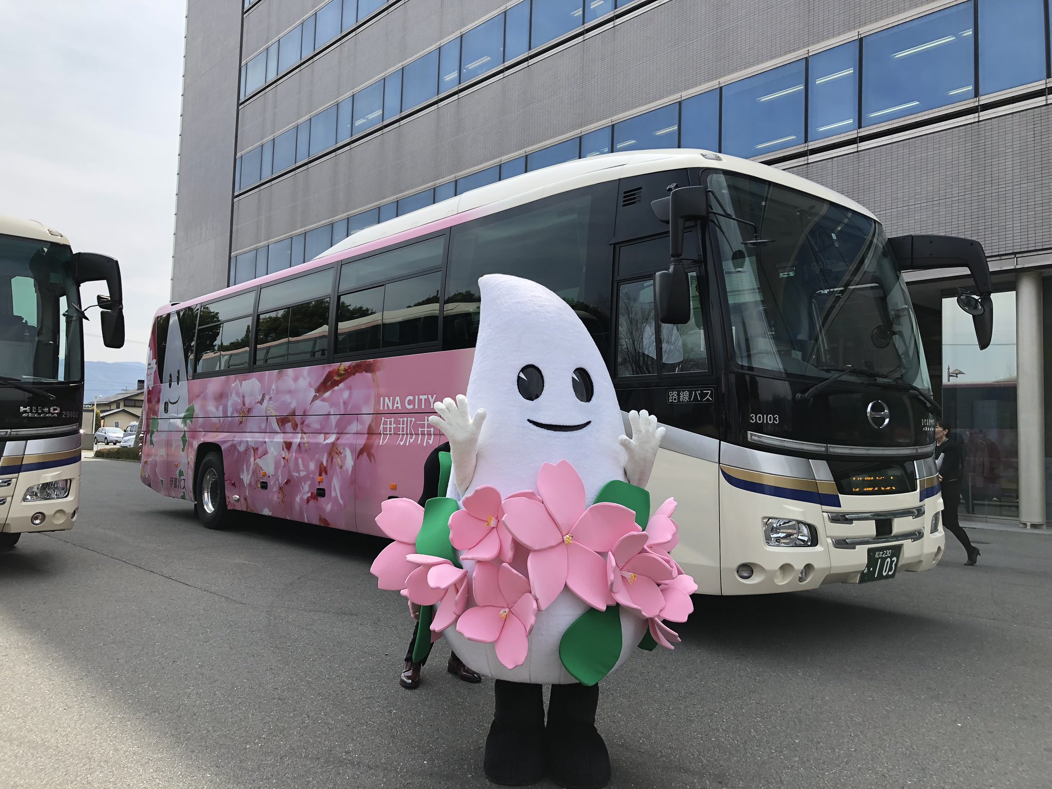 おいでな伊那 伊那市観光協会 新宿 伊那市をつなぐ 高速バスに 新しいラッピングバスが走ります 伊那市の花 桜と バラをモチーフにした目を引くデザイン キャラクターのイーナちゃんも大きく描かれています 明日から新宿飯田線で通常運行されます