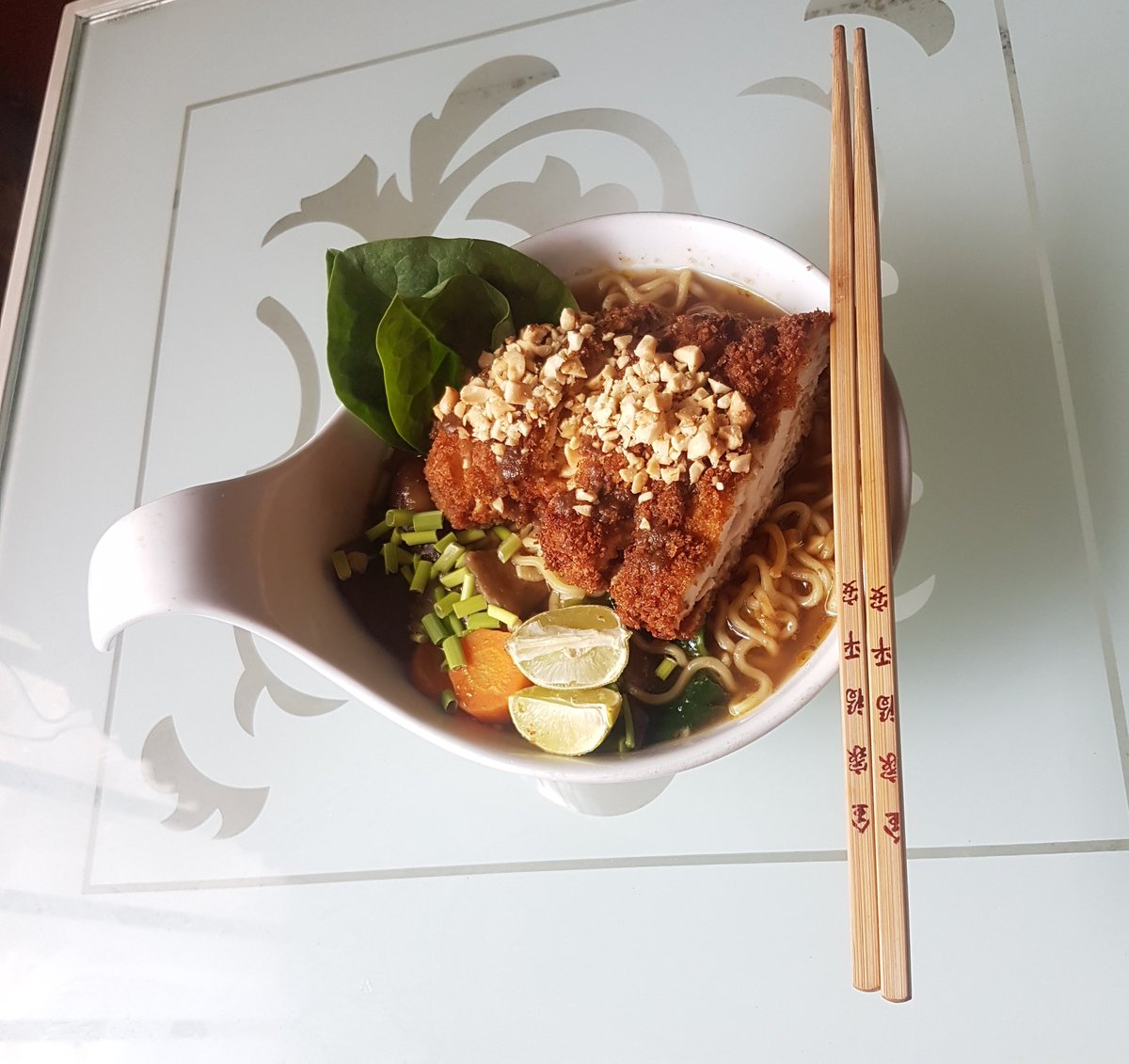 Quarantine cuisineLunchChicken peppersoup "ramen" (chicken peppersoup Indomie, ginger, garlic, mushrooms, carrots and spinach) with a chicken cutlet katsu topped with chopped roasted peanuts