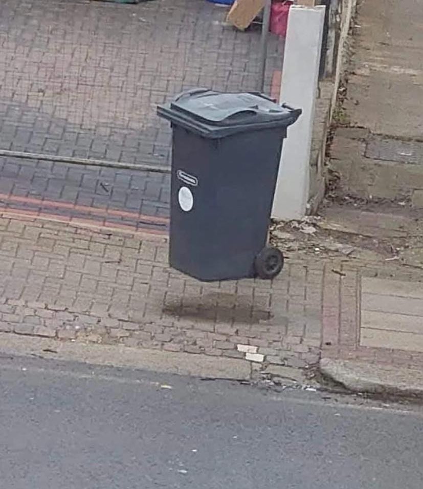 You may see a floating bin, but if you do it just means you’ve been in the house too long.What you’re seeing is a wet spot on the pavement.