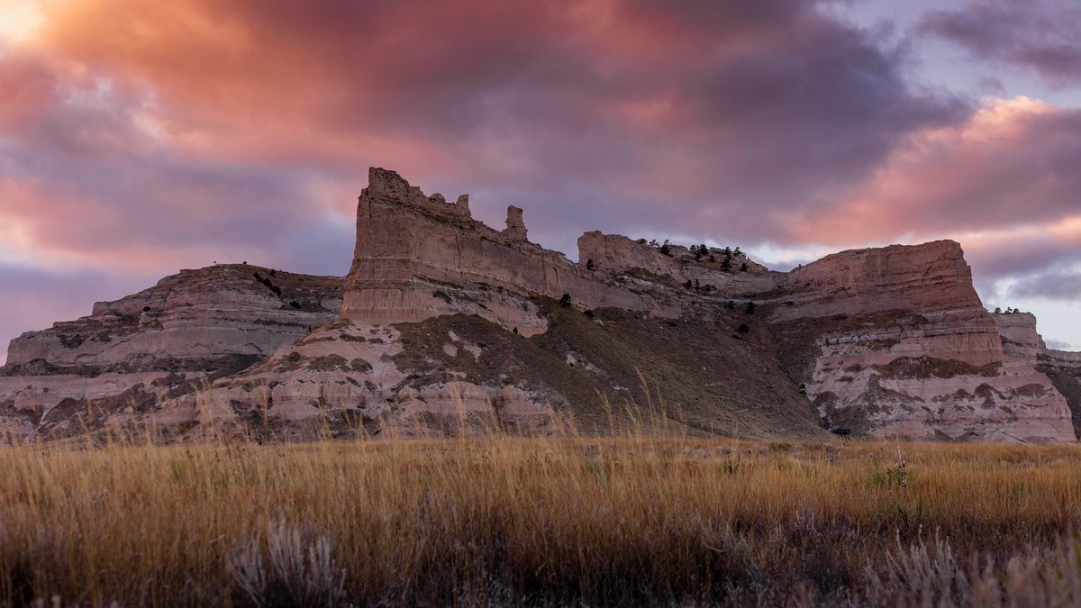 Interior's tweet photo. Under a purple sky, @ScottsBluffNPS rises like a mighty fortress above the grassy plains #Nebraska #VirtualVisit https://t.co/iSHeE0pZkz