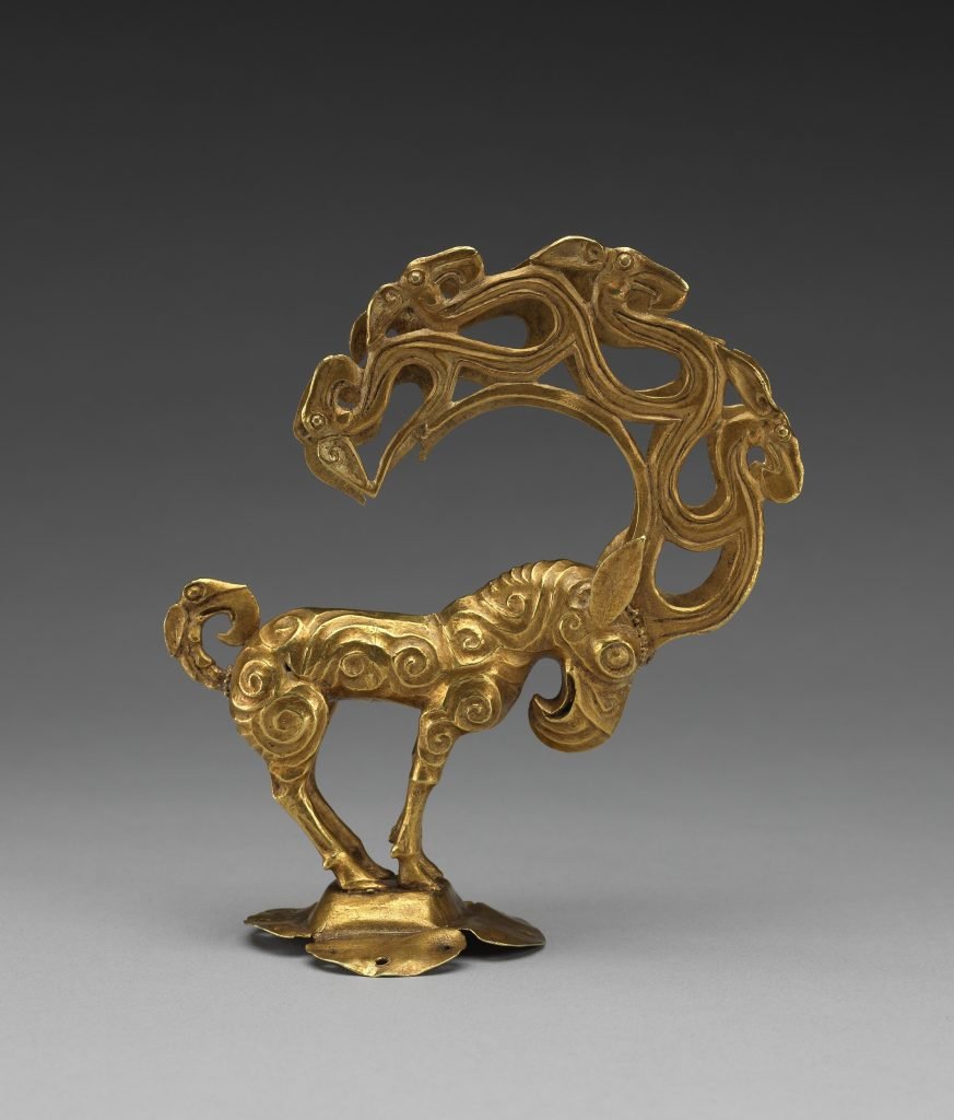 The motif of a stag with antlers sprouting into tree branches and bird heads is also attested widely accross the nomadic world since the late Bronze Age. Compare with the golden head finial from Shenmu in northern Shanxi (source:  https://www.natgeomedia.com/travel/article/content-4359.html) 7/11