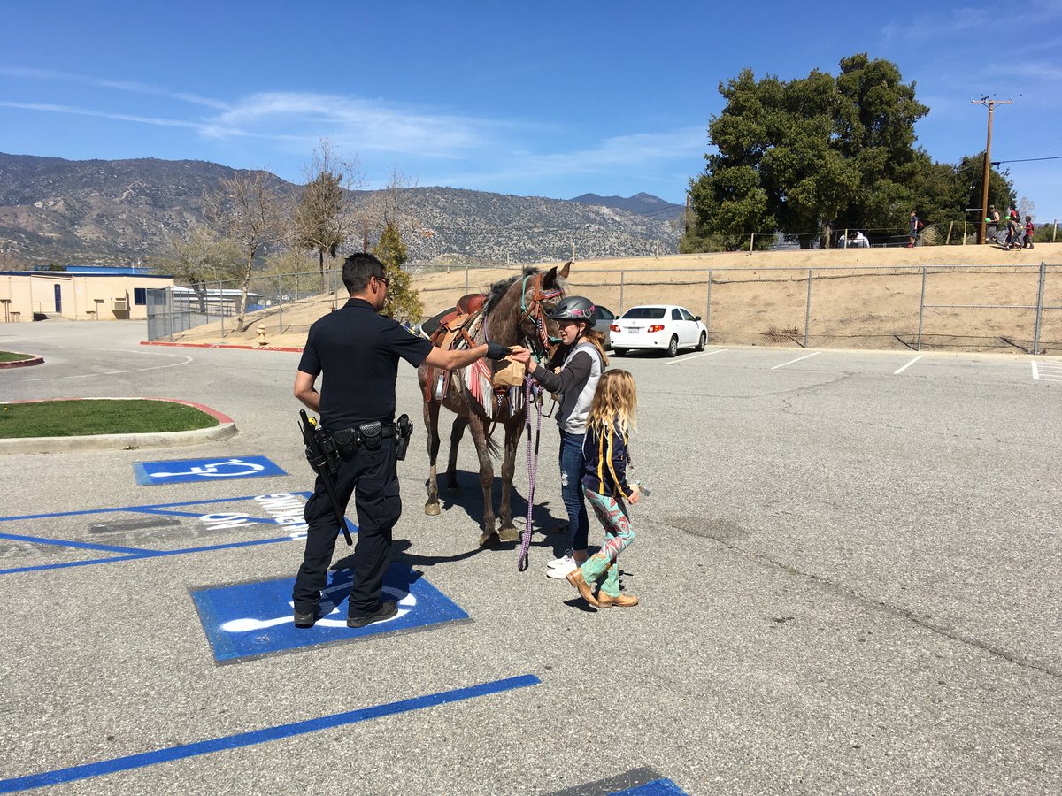 KHSD_Official's tweet photo. You don't see this every day at school! @KVHSBroncs Officer Olivares handing out a meal to a girl who rode up on her horse! https://t.co/rgbbbV8Sd0