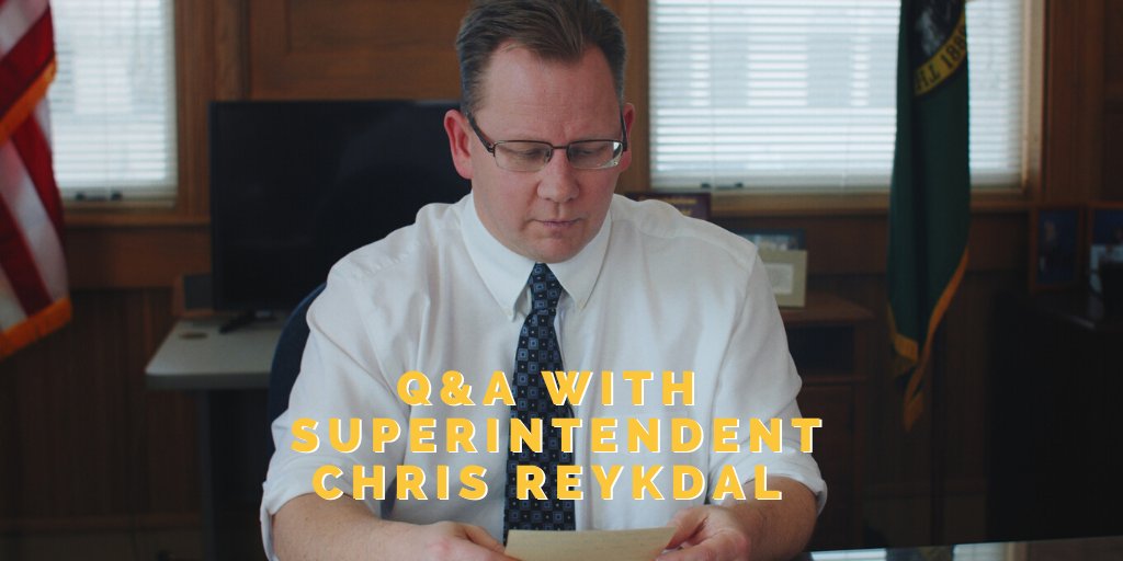 Photo of Superintendent Reykdal at his desk, looking down at a notecard. Text overlaid says "Q&A with Superintendent Chris Reykdal."
