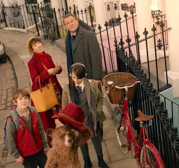 Jonathan is the next to melt to the bear’s charms. The red in his jacket indicates a Paddington-positive attitude. Soon enough, Judy has red detail in her school uniform (and it’s at school that her transformation occurs). But Mr Brown is all blues, greys & tie properly tied...
