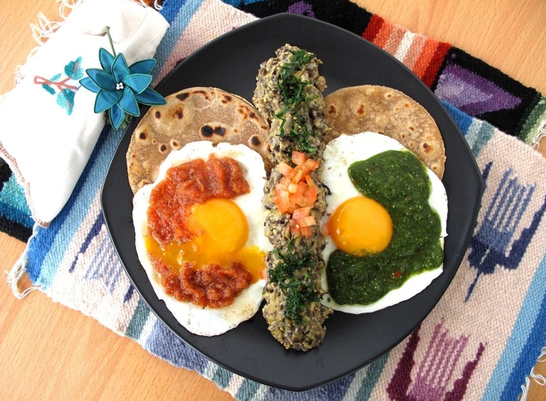 The Huevos DivorciadosHhmuevos divorciados literally means divorced eggsThis dish includes two sunny side up fried eggsOne egg topped with green & cooling salsaThe other a red & spicy salsa, hence the name. Accompanied by beans & sliced avocado #VirtualMexicanRoadTrip