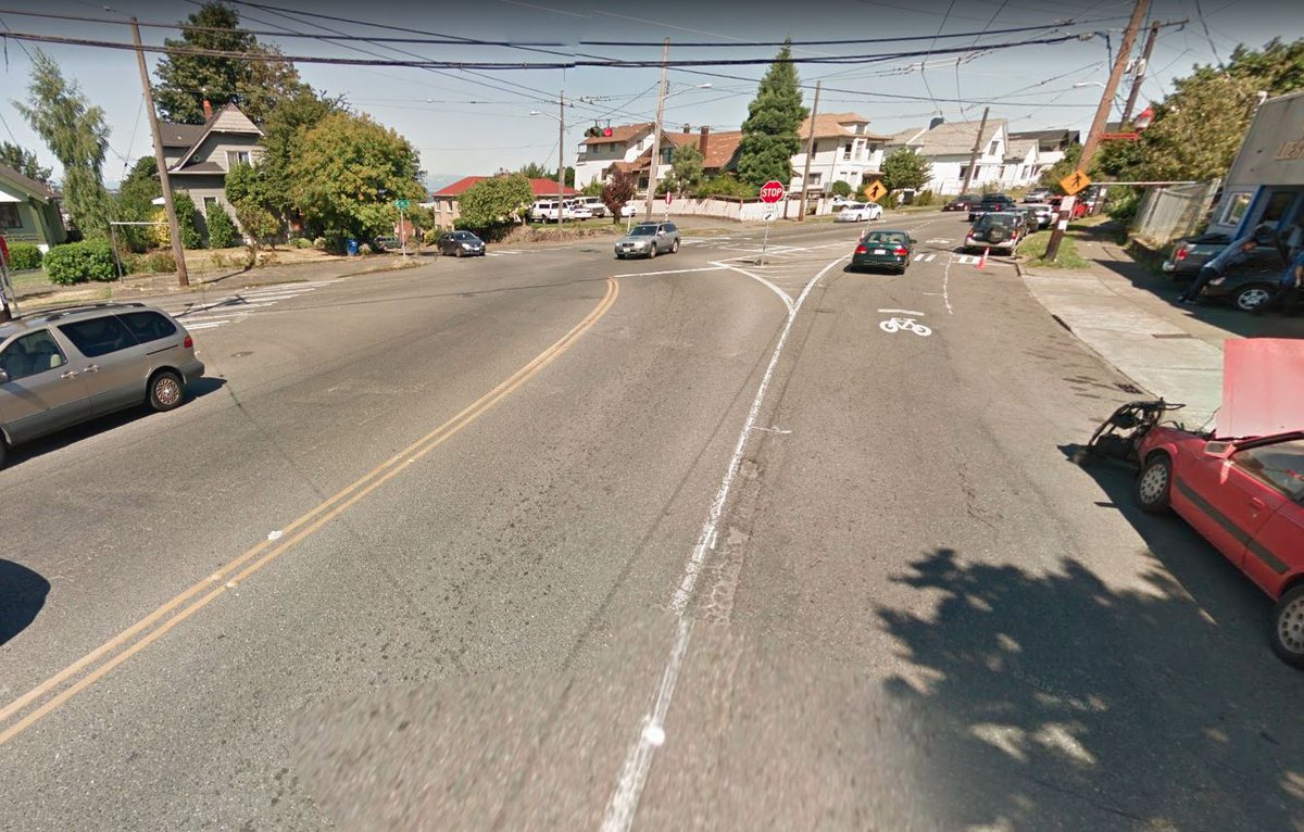 Intersection approach on Beacon Ave with the old slip lane and with it revised. New crossing and space for people.