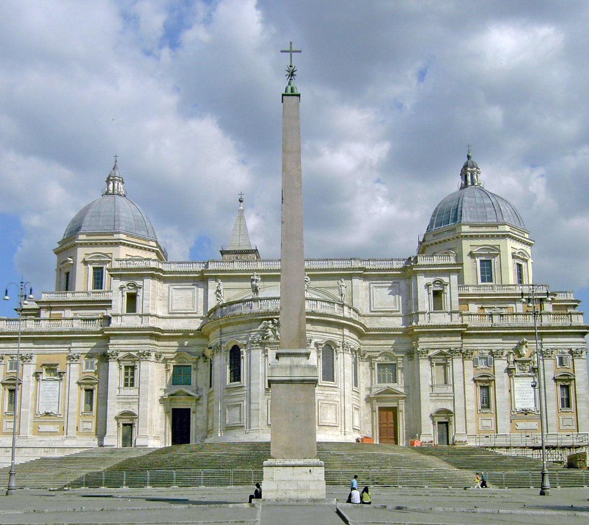 Detrás de la iglesia, veremos el obelisco esquilino. Y frente a la iglesia, la columna de la paz, coronada por la Virgen. Esa columna pertenencia a los restos de la basílica de Magencio.