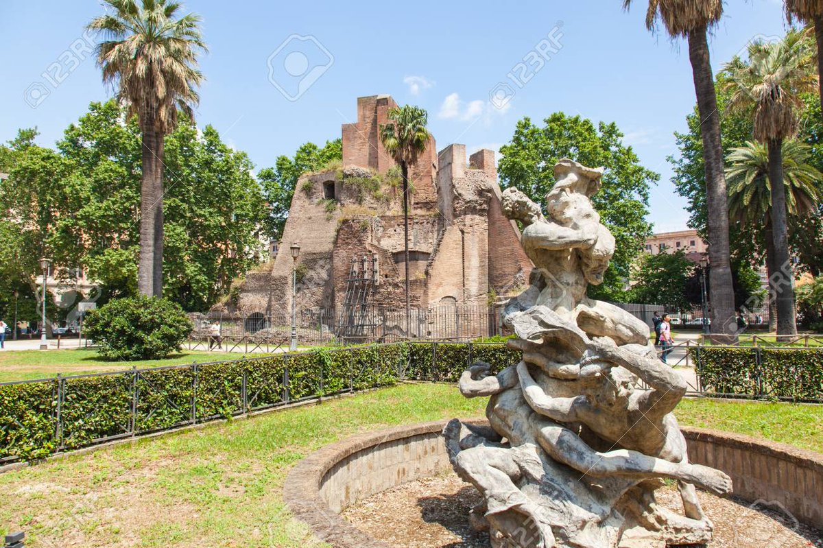 Llegamos a la piazza Víctor Emanuel II. Llaman la atención tres cosas. 1. El ninfeo de Alejandro Severo, conocido también como "Trofeo de Mario".2. La puerta mágica, exótica y pitagórica.3. La escultura central, que antes estaban en lo que es hoy la fuente de las nereidas.