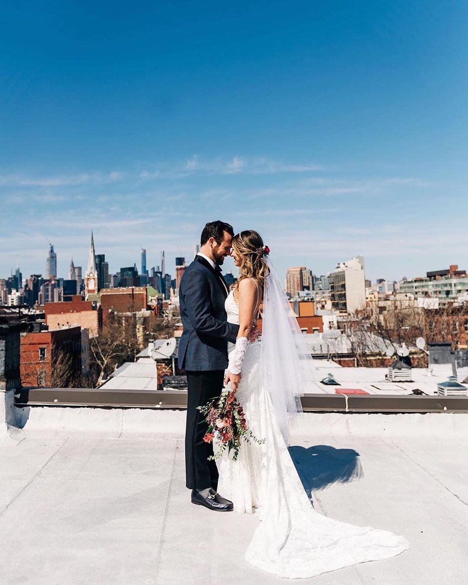 WeddingWire's tweet photo. I do with a view! 🏙️💙Paula &amp; Ken rescheduled their big celebration until 2021, but said "I do!" on their original date. The couple was married on their private rooftop in Brooklyn while neighbors watched from fire escapes. ✨ {Yumi Matsuo Studio} https://t.co/aMIMrjMHlX