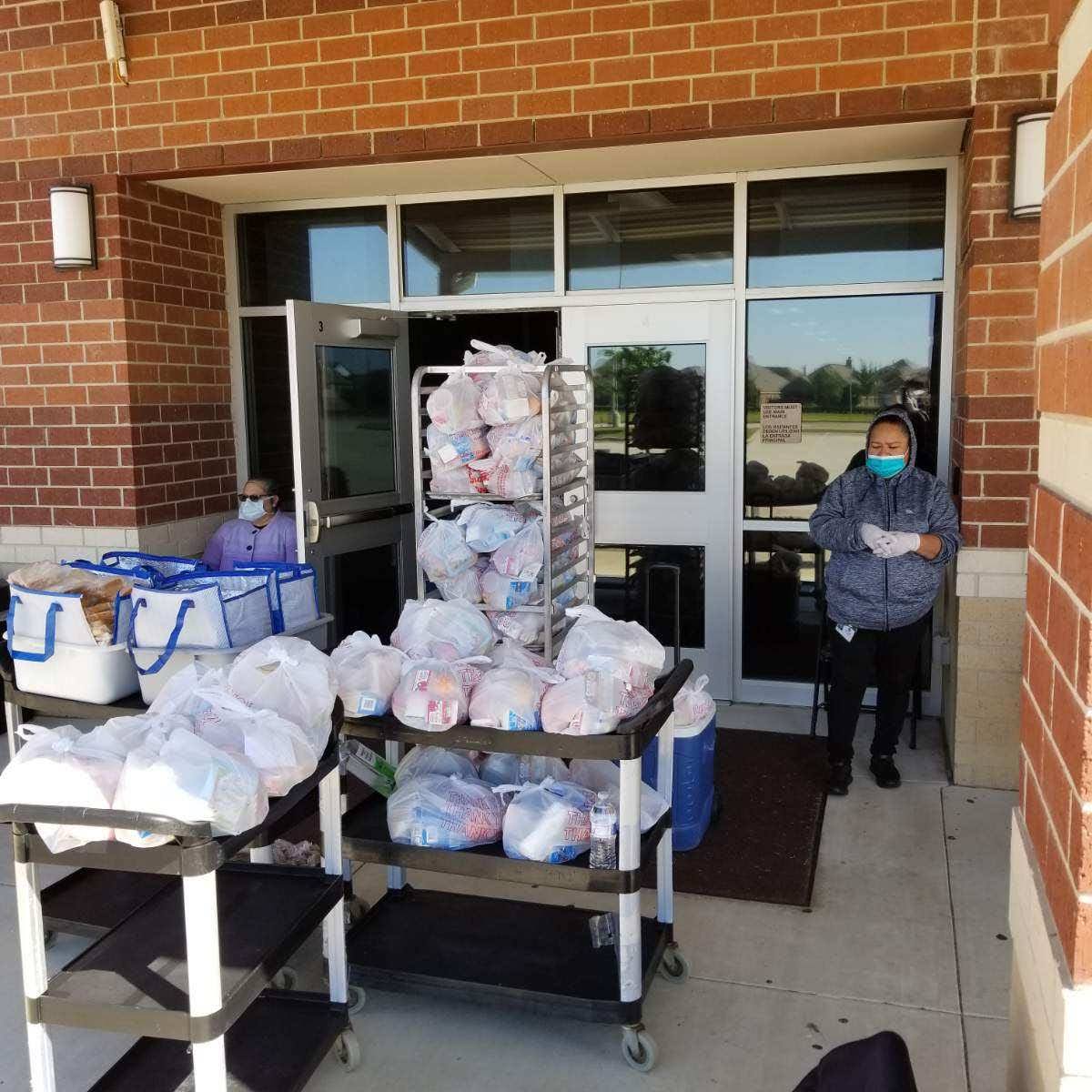 CIS Staff helping with Grab and Go lunches.  We are giving out packets to students who don't have access to necessary technology for online learning.