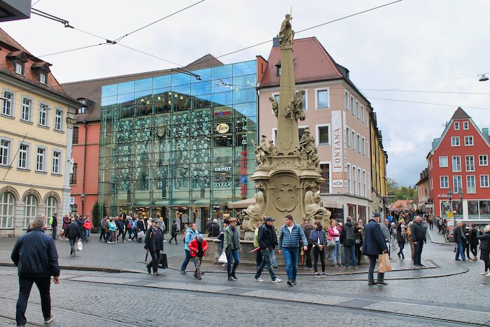 As we walk into town, we can see the Alte Mainbrücke ahead of us. Don’t be distracted, keep walking underneath the bridge then turn right to the square in front of our town hall (Rathaus). Pop in to the pretty little courtyard.