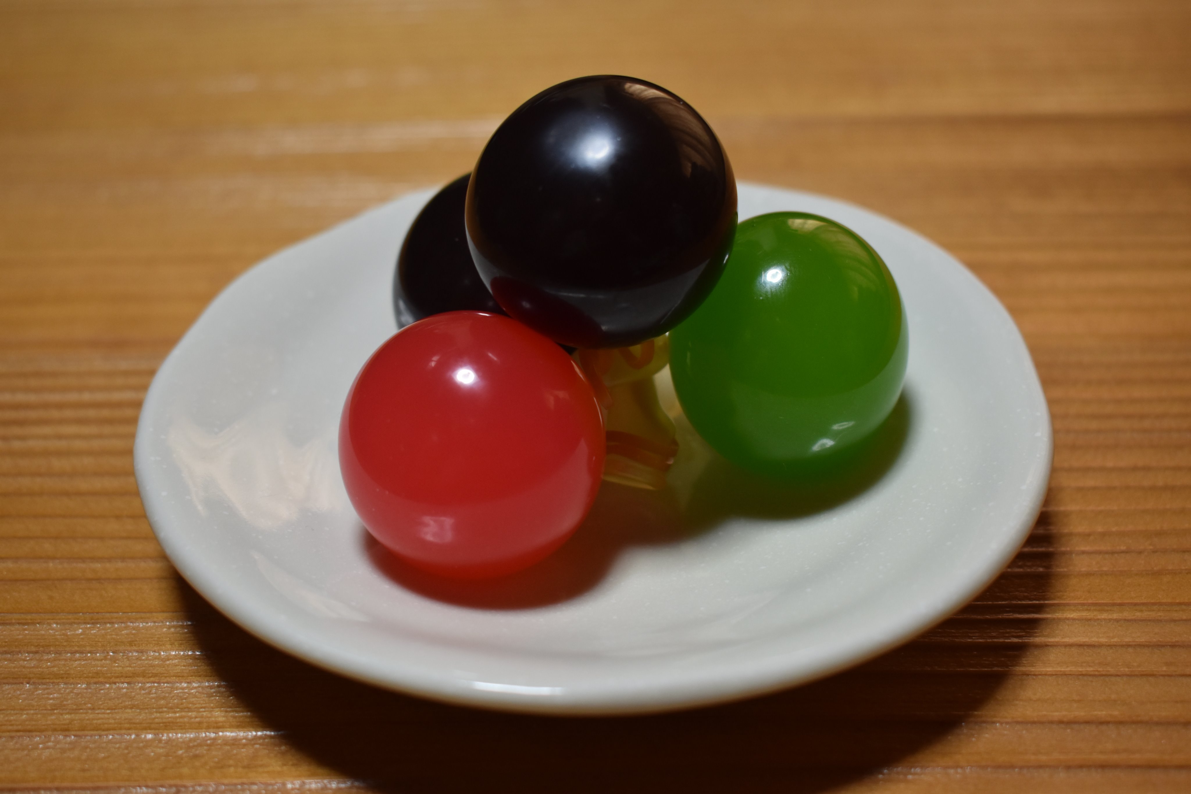 光惟 菓子暦 今朝はちょっと目先を変えて 玉羊羹 小さなゴム風船の中に羊羹を入れた普段菓子 何か楽し気な感じですが誕生のきっかけは日中戦争だったそうです Tvは 時局は戦時下と同じ とコロナウイルス禍の緊迫感を伝えています これを目に