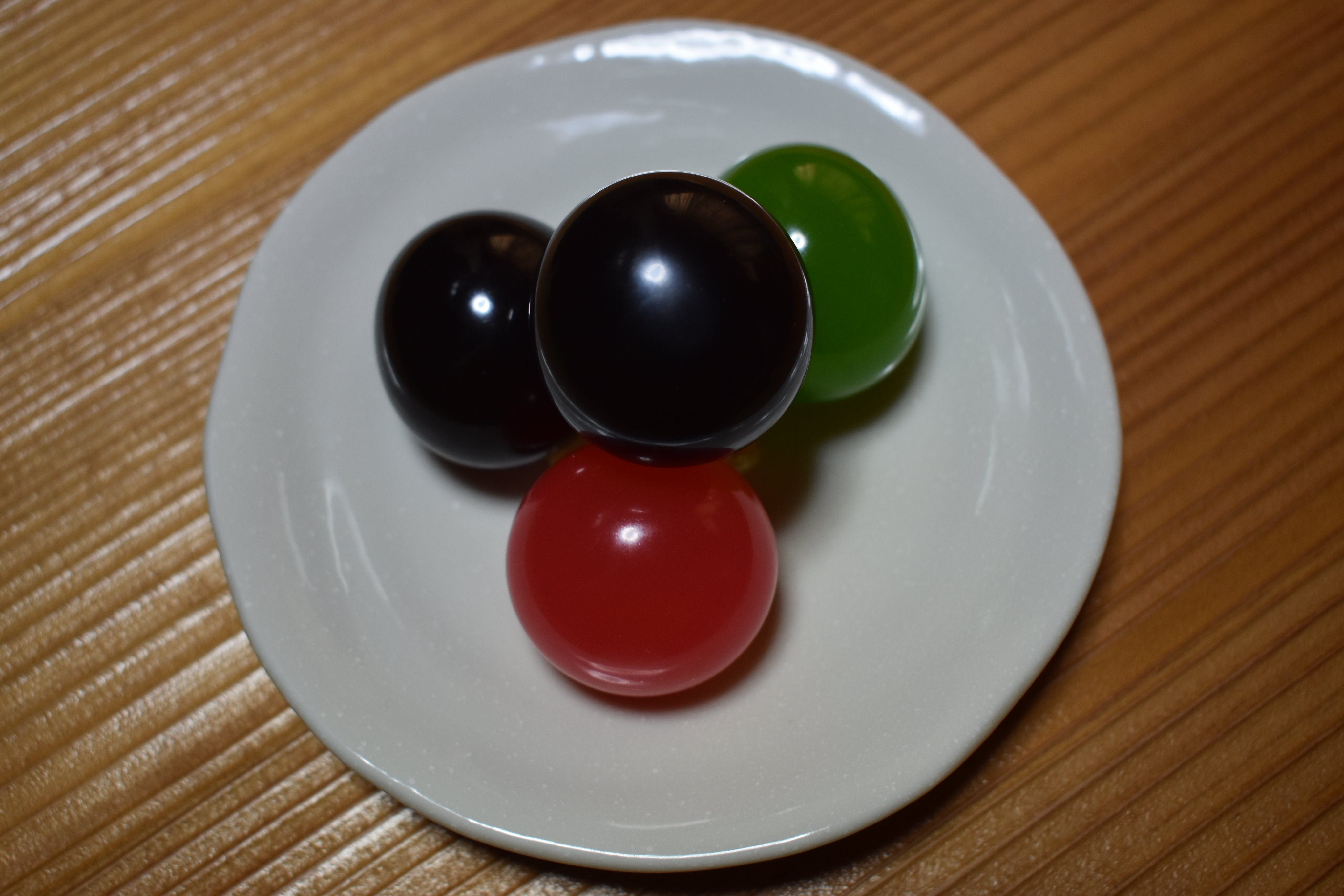 光惟 菓子暦 今朝はちょっと目先を変えて 玉羊羹 小さなゴム風船の中に羊羹を入れた普段菓子 何か楽し気な感じですが誕生のきっかけは日中戦争だったそうです Tvは 時局は戦時下と同じ とコロナウイルス禍の緊迫感を伝えています これを目に