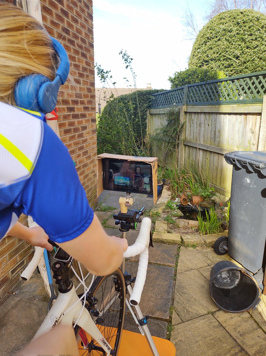 CraigRo25544803's tweet photo. Indoor training, outdoor set up. Jessamine 11 enjoying @manonlloyd96 commute live stream. #StayInWorkOut  #gcnhack tripod screen mount #sunscreen https://t.co/2yhiCwnz7N
