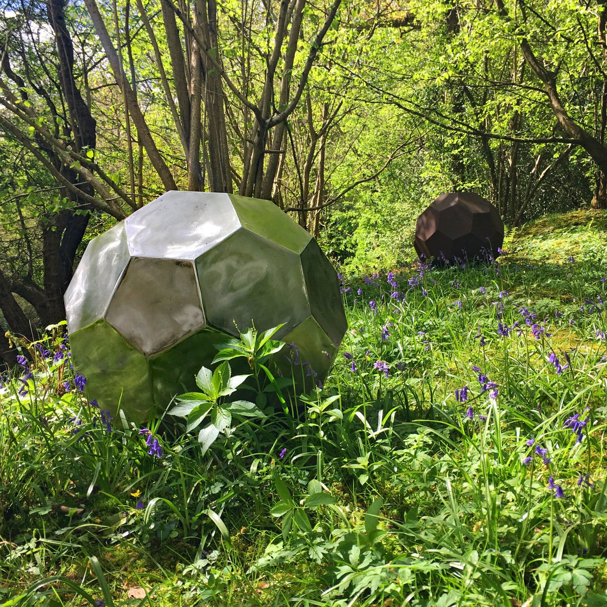 Hannah_Peschar's tweet photo. Crips lines and urban materials provide a striking contrast to the surrounding fragility of fresh spring shoots & wild flowers. #RobHarding's 'Fronteras', created from stainless and mild steel, look particularly captivating at this time of year surrounded by beautiful bluebells! https://t.co/3E0I37Qln8
