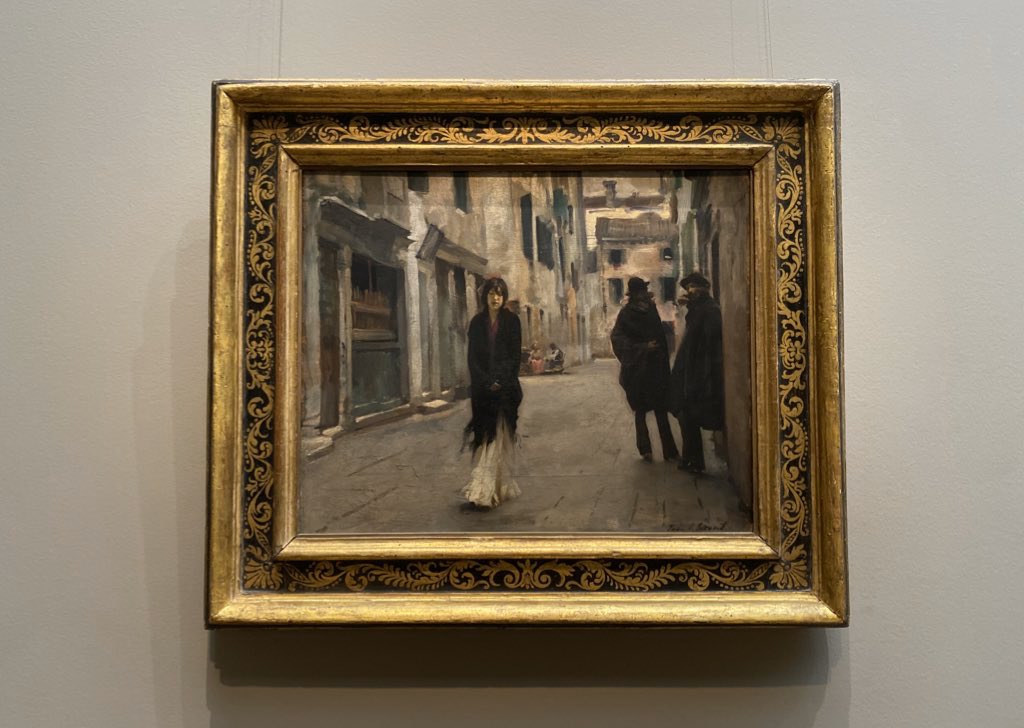 Sargent executed “Street in Venice” in 1882, capturing a transitional moment when his model, walking near Venice’s Grand Canal, is being observed by one of two men conversing before a stone doorway.
